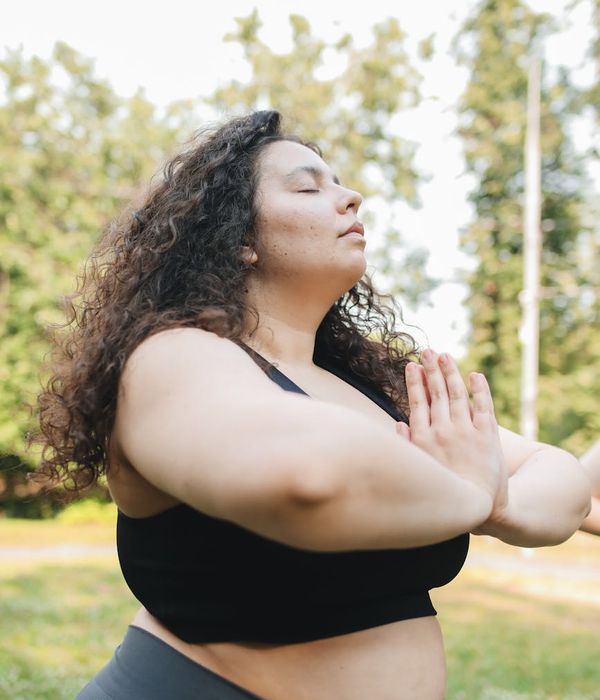 Woman practicing calm breathing exercise in a serene natural environment.